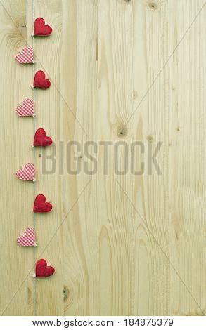 Nine hearts with clothes pegs on a cord on wood