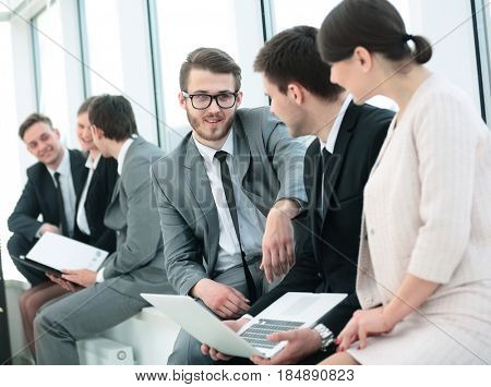business team with laptop and documents sitting in the lobby bef