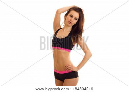a young girl with a nice slender body in a black tank top and shorts and poses for the camera isolated on white background