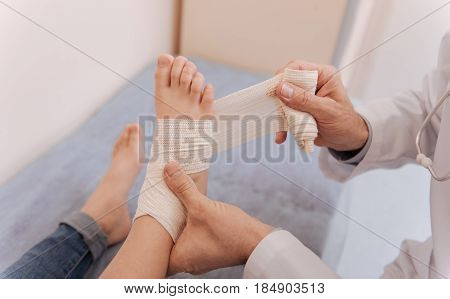 For protection purposes. Nice attentive neat rheumatologist being very careful while using special elastic string for treating patients joints