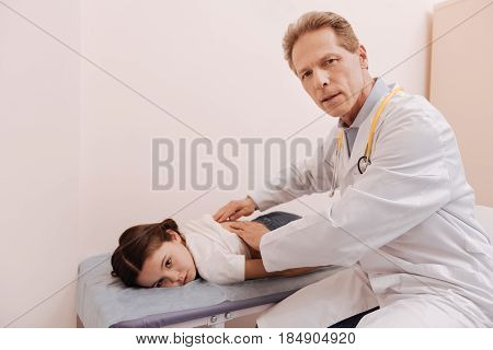 We need a scan. Worried emotional accomplished rheumatologist giving a professional consultation and figuring out the diagnosis while examining childs spine