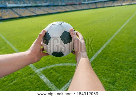 person holding soccer ball on soccer field stadium