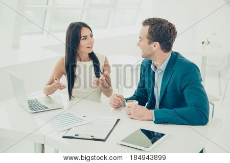Two businesspeople having a meeting in a restaurant discussing their new strategy and drinking coffee