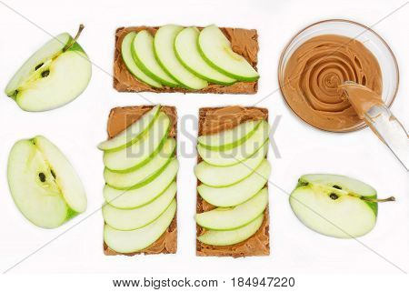 Sandwiches with peanut butter and an apple on the table close-up. Apple slices walnuts isolated on white background. Horizontal top view.