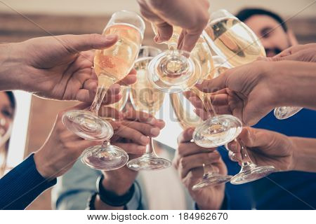 Cropped Under View Of Friends Cliking The Glasses Of Bubbling Champagne To Celebrate An Event Togeth