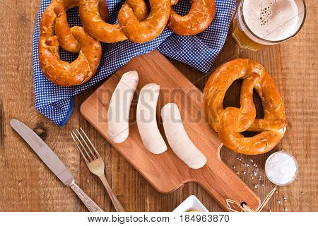 Bavarian pretzels with saisages on cutting board.