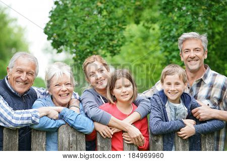 Portrait of happy family leaning on fence