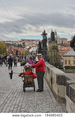 PRAGUE CZECH REPUBLIC - NOVEMBER 5 2012: A man plays on a hurdy-gurdy at the Charles Bridge in Prague