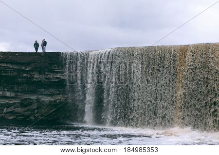 JAGALA, ESTONIA - APRIL 30, 2017: People stand on top of Jagala Waterfall, the highest natural waterfall in Estonia with height about 8 meters.