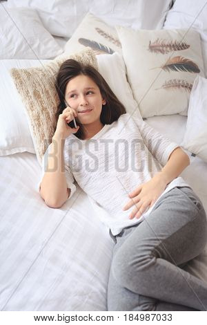 Pretty teenage girl talking on phone about her intimacy secret