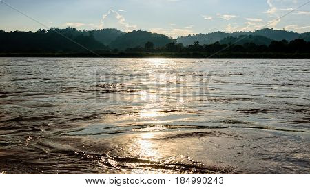 Beautiful natural landscape surface water of the Mekong River reflects golden sunlight during sunset in Thailand 16:9 wide screen