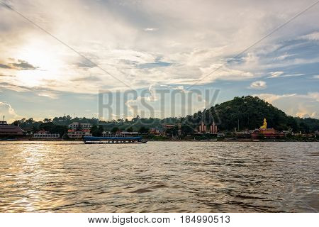 Beautiful natural landscape and tourist boat cruising the beauty of the Mekong River coast at sunset in the Golden Triangle Park (Sob Ruak) in Chiang Rai Province Thailand
