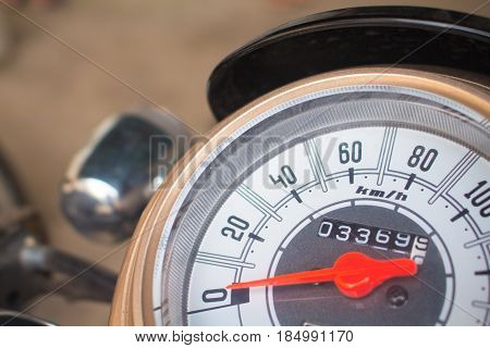 Speedometer on motorcycle dashboard. Round speedometer with red arrow. Speed zero shown. Full stop of motorbike. Transport closeup photo. Motorbike electric gear. Concept image for stagnation
