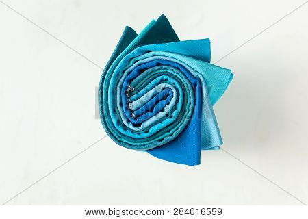 Colorful Fabric Swatches Rolled Up On White Background.