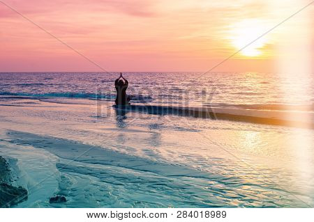 Yoga Silhouette. Meditation Fitness Woman Sitting On Beach During Amazing Sunset. Healthy Lifestyle.