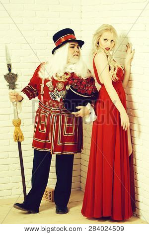 Senior Man Beefeater Yeomen Warder In Uniform With Flowers And Spear And Pretty Girl Young Sexy Blon