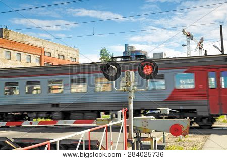 A Passenger Train Moves Along The Route.and The Railway Crossing Was Closed.