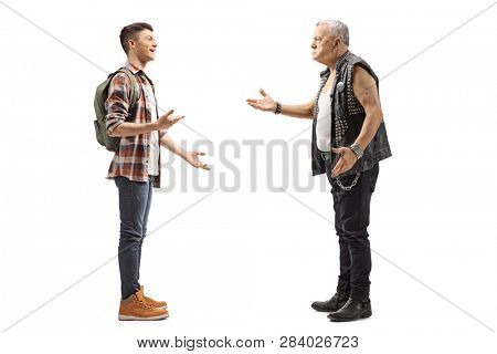 Full length profile shot of a male teenage student talking to a mature male punker in a leather vest isolated on white background