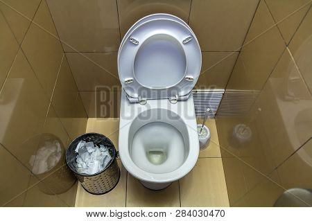 Interior Of Simple Restroom Toilet, View From Above. White Ceramic Toilet Lavatory Ceramic Seat On C