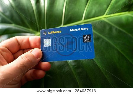 Frankfurt, Germany - Dec 18, 2018: Man Hodling Against Green Leafe Background A New Lufthansa Miles 