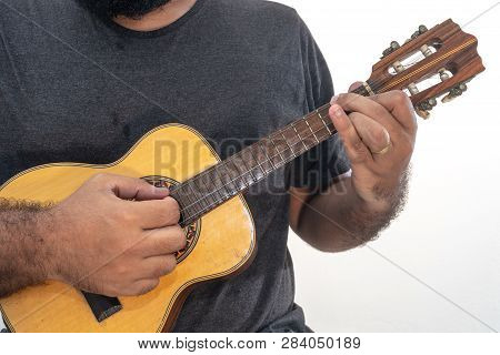 Young Man Playing Ukulele With Shirt And Black Pants.