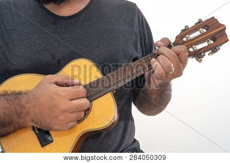 Young Man Playing Ukulele With Shirt And Black Pants.