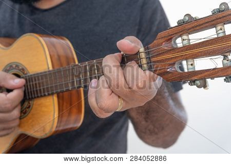 Young Man Playing Ukulele With Shirt And Black Pants.