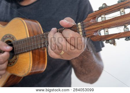 Young Man Playing Ukulele With Shirt And Black Pants.