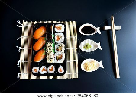 Close Up Top View Accessories With Chopstick And Small Plate With Sauces For Sushi On Black Backgrou