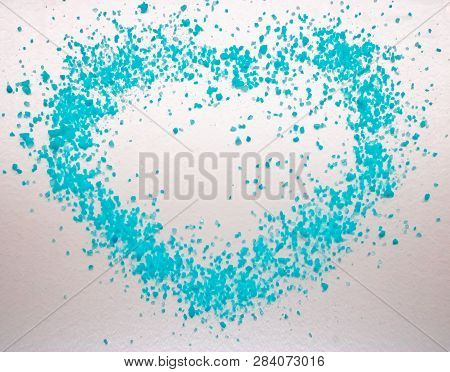 Heart-shaped Blue Salt On The White Background. Organic Blue Sea-salt Scattered On The White Backgro
