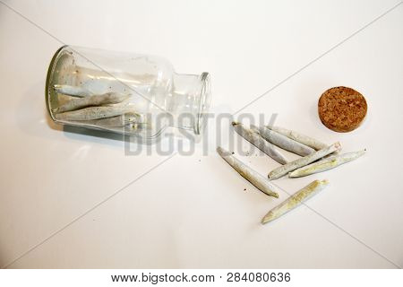 Marijuana Joints. Cannabis. Recreational Marijuana or Medical Cannabis in a glass jar. isolated on white. room for text. Joint aka Spliff or cigarette.  

