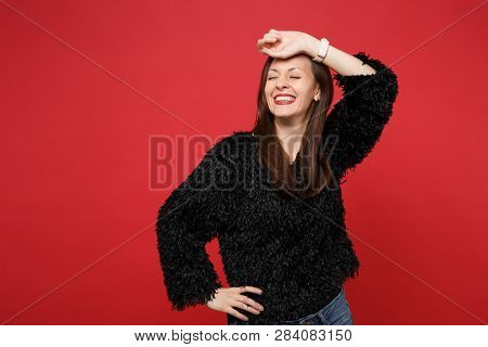 Stunning Relaxed Young Woman In Black Fur Sweater With Closed Eyes Keeping Hand On Forehead Isolated
