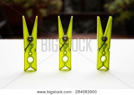 Three Yellow Clothespins With The Blurred Background
