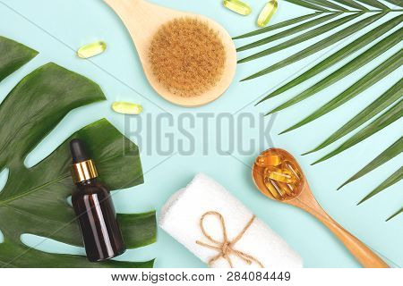 Spa And Wellness Concept. Tropical Leaves, Towel, Face Or Body Brush, Fish Oil Capsules And Essentia