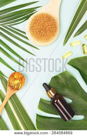 Spa And Wellness Concept. Tropical Leaves, Towel, Face Or Body Brush, Fish Oil Capsules And Essentia