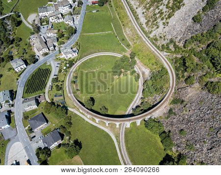 Aerial Drone Image Of The Brusio Spiral Viaduct - A Single-track Nine-arched Stone Spiral Railway Vi