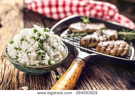 Rice Basmati With Green Peas In Bowl And Grilled Chicken Breast In The Background