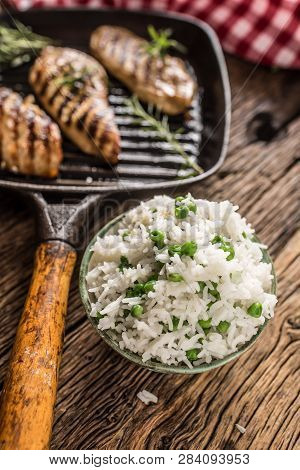 Rice Basmati With Green Peas In Bowl And Grilled Chicken Breast In The Background