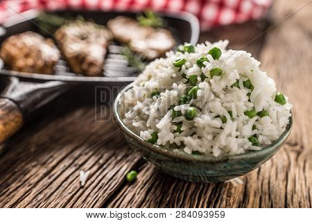 Rice Basmati With Green Peas In Bowl And Grilled Chicken Breast In The Background