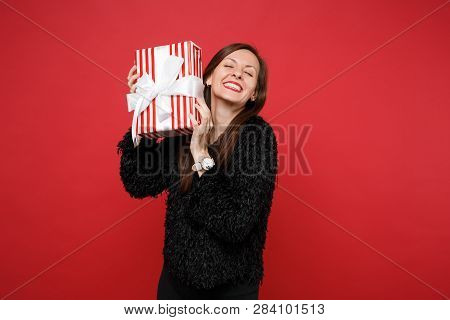 Pretty Young Woman With Closed Eyes Hold Red Striped Present Box With Gift Ribbon Isolated On Red Ba
