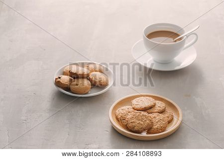 Cup Of Coffee With Milk Or Cappuccino With Cookies On Light Stone Background. Drink With Caffeine Or