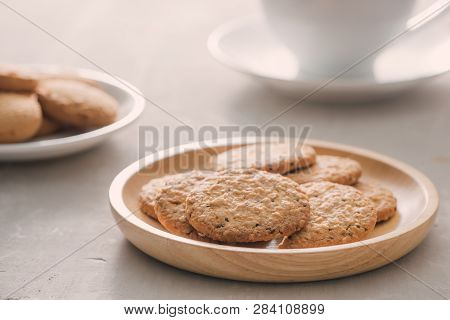 Cup Of Coffee With Milk Or Cappuccino With Cookies On Light Stone Background. Drink With Caffeine Or