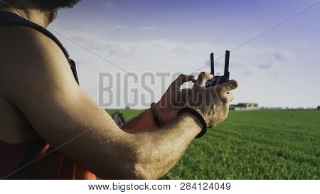 Bearded Male Model Use Drone Remote Control To Fly Device In Air.quadro Copter Drone Flying Over Sun