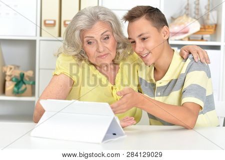 Portrait Of Grandson And Grandmother Using Tablert