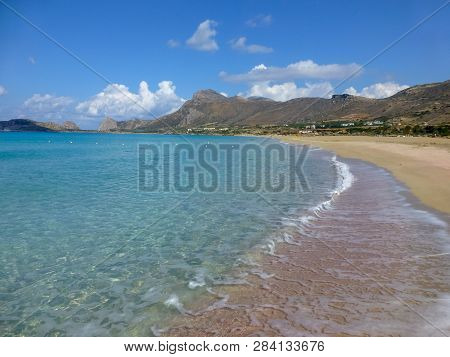 Surf Waves On Famous Pink Falassarna Beach With White And Pink Sand And Exotic Blue Waters On Crete