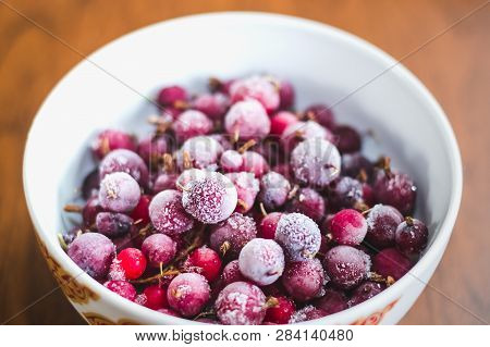 A Mixture Of Red Frozen Berries Of Currant And Gooseberry Covered With White Frost In A White Plate 