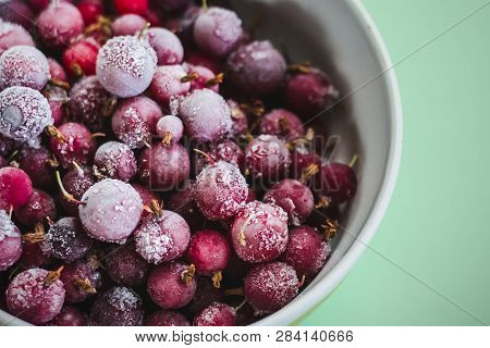 A Mixture Of Red Frozen Berries Of Currant And Gooseberry Covered With White Frost In A White Plate 