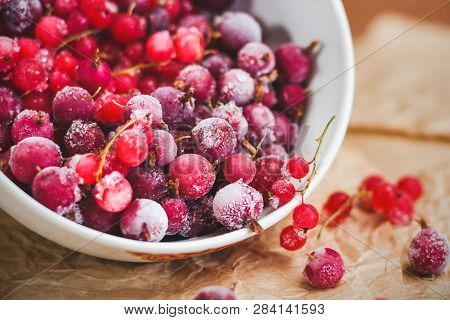 Red Frozen Berries Of Currant And Gooseberry, Covered With White Frost, In A White Plate And On The 