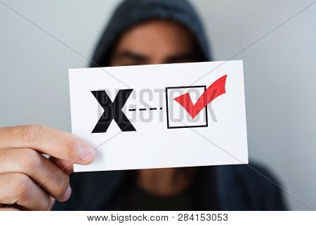 closeup of a young caucasian person holding a piece of paper with a X written in it, for the third gender category