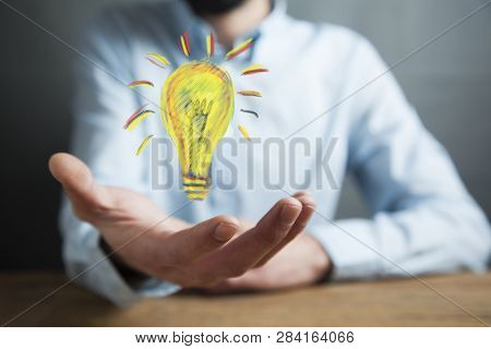 Man Hand Light Bulbin  Screen On Table